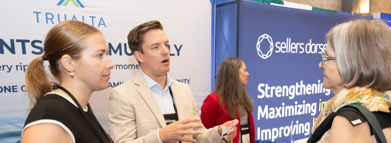 Conference sponsors speak with an attendee