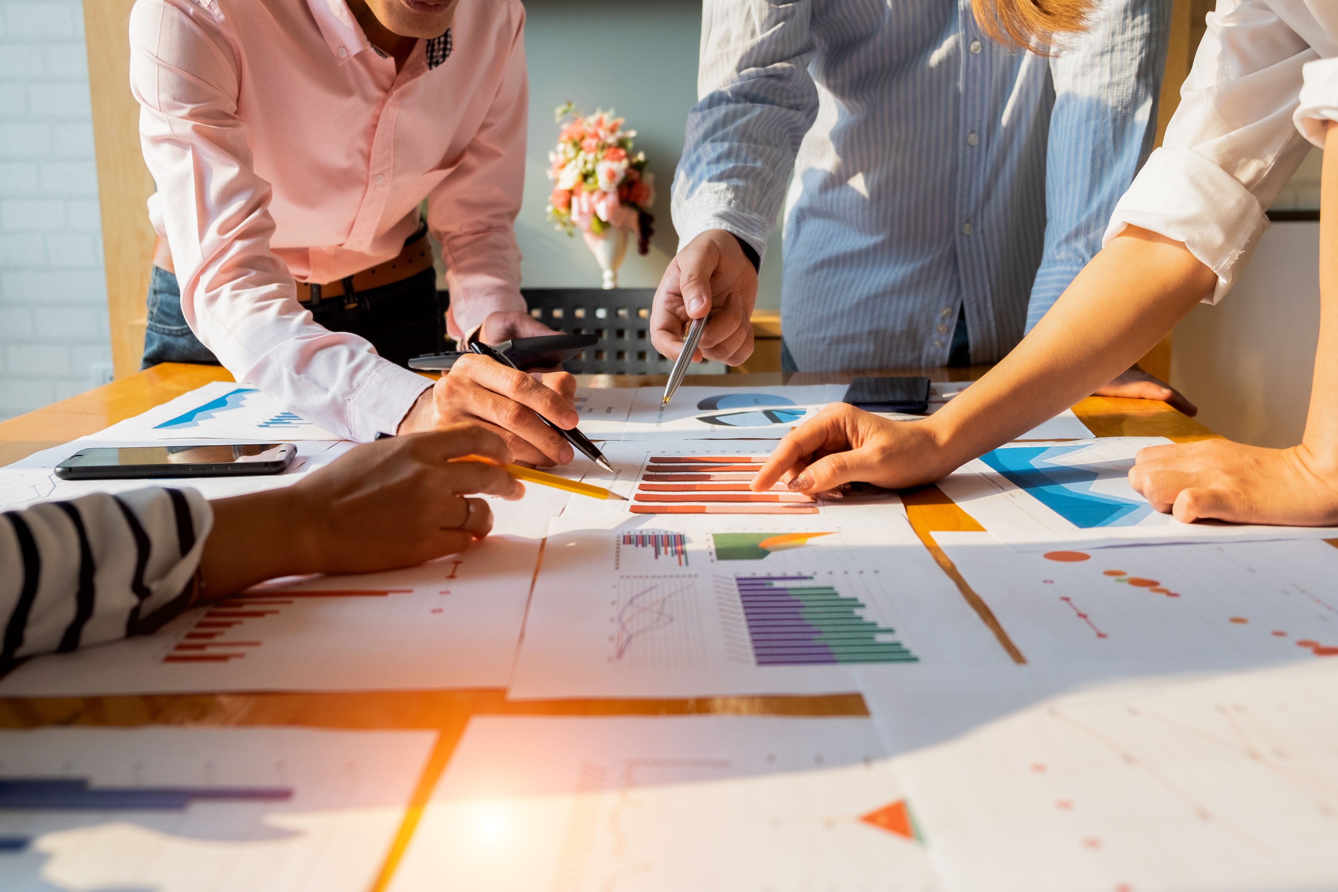 team analyzing data documents spread across a table