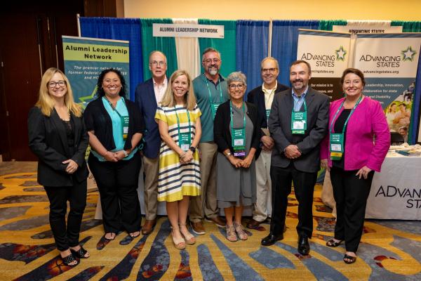 a group of professionals in front of a conference exhibit booth